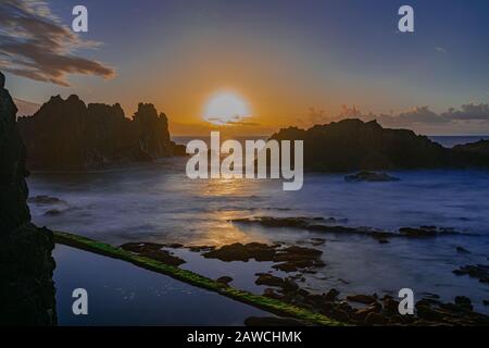 Coucher de soleil sur l'horizon de l'océan Atlantique, avec formation de roches volcaniques, longue exposition, El Prique, Tacoronte, Tenerife, îles Canaries, Espagne Banque D'Images