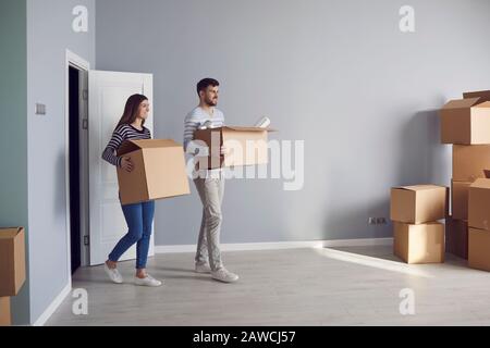 Famille de jeunes couples avec des boîtes pour se déplacer dans une nouvelle maison. Banque D'Images