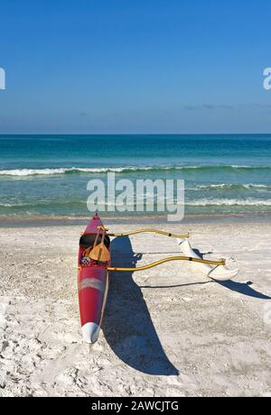 Un canoë-kayak à l'extérieur assis sur une plage de sable blanc avec l'océan en arrière-plan Banque D'Images