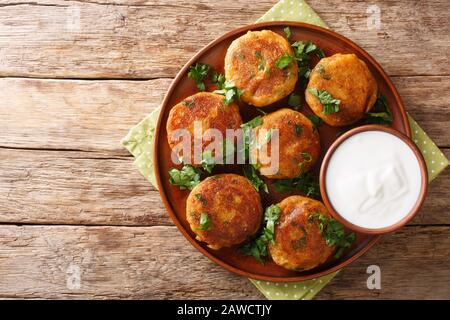 Pâtés de pommes de terre indiens Aloo Tikki servi avec du yaourt près dans un plat sur la table. Vue de dessus horizontale Banque D'Images