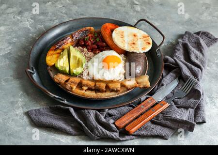 La nourriture colombienne. Bandeja paisa, plat typique dans la région d'Antioquia en Colombie - chicharron (ventre de porc frit), boudin noir, saucisse, arépa, haricots, Banque D'Images