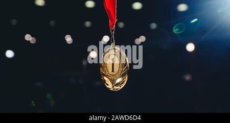 Première place de la médaille d'or sur fond sombre et flou. Banque D'Images