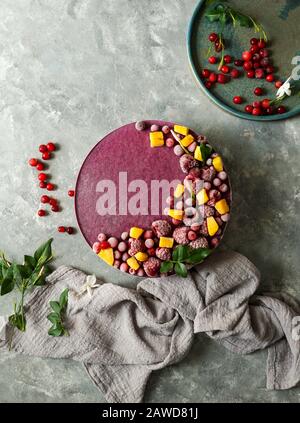 Cheesecake cru végétalien avec bleuets, cerises, thé matcha, orange, crème de noix de cajou, beurre de coco et lait de noix de coco, et base faite d'amandes, dates et Banque D'Images