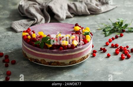 Cheesecake cru végétalien avec bleuets, cerises, thé matcha, orange, crème de noix de cajou, beurre de coco et lait de noix de coco, et base faite d'amandes, dates et Banque D'Images