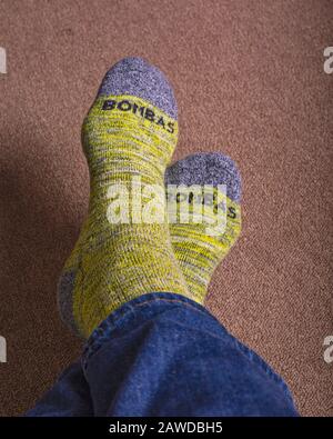 Chaussettes de mollet jaune à motif Bombas portées avec un Jean bleu. Banque D'Images