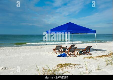 Abri portable avec chaises longues et tables sur la plage Banque D'Images
