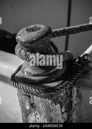 Corde enroulée autour d'un poteau en bois sur un petit bateau. Banque D'Images