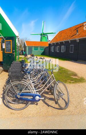 Zaanse schans, Pays-Bas - 1er avril 2016 : rangée de vélos à louer, moulin à vent dans le village traditionnel, Hollande du Nord, maisons vertes Banque D'Images