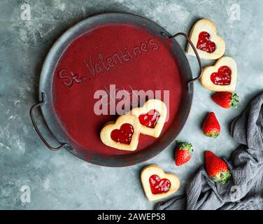 Mot St Valentin, écrit sur le plateau, recouvert de poudre de fraises gélosées, conséctrice de jour d'amour Banque D'Images