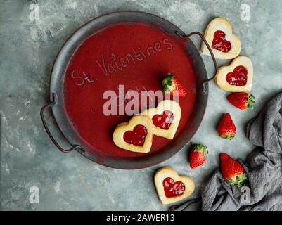 Mot St Valentin, écrit sur le plateau, recouvert de poudre de fraises gélosées, conséctrice de jour d'amour Banque D'Images