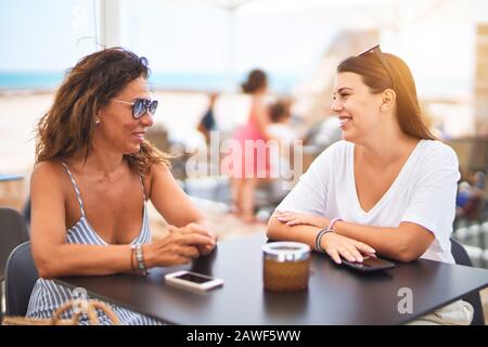 Belle Mère et fille assis à une terrasse de restaurant parlant et souriant Banque D'Images