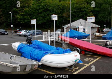 Canot zodiaque et bateaux dans les baies de stationnement de bateaux dans le parking de ferry, Fowey , Cornwall , Angleterre Banque D'Images