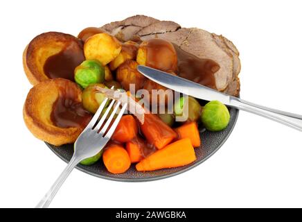 Dîner traditionnel de bœuf rôti avec pommes de terre rôties et Yorkshire pudding et légumes, isolé sur fond blanc Banque D'Images