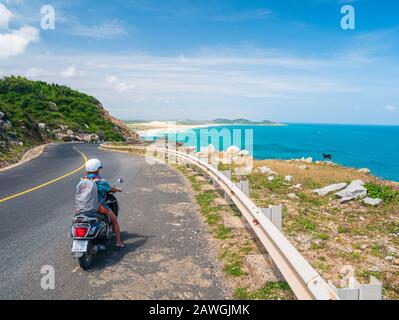 Une personne qui fait de la moto sur une route sinueuse en regardant la magnifique côte dans la province de Phu Yen, Nha Trang Quy Nhon, aventure en voyage au Viet Banque D'Images