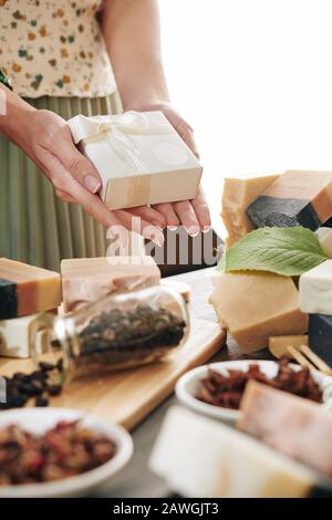 Mains de femme tenant une petite boîte avec savon bar qu'elle a fait à la maison Banque D'Images