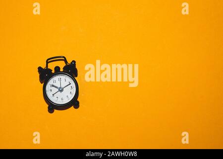 Réveil classique sur fond jaune. Montre rétro avec cadran rond. Espace de copie Banque D'Images