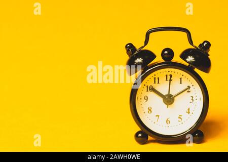 Réveil classique sur fond jaune. Montre rétro avec cadran rond. Espace de copie Banque D'Images