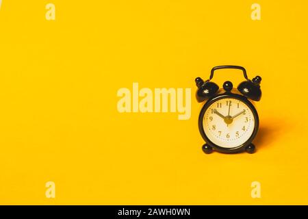 Réveil classique sur fond jaune. Montre rétro avec cadran rond. Espace de copie Banque D'Images