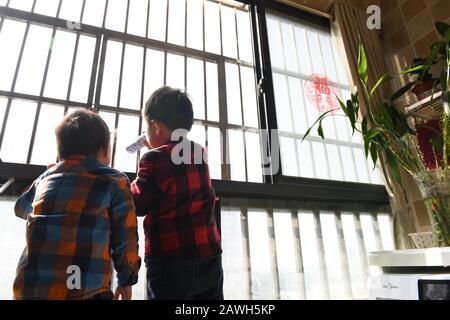 (200209) -- HEFEI, 9 février 2020 (Xinhua) -- fils de Fang Ji regarder vers l'hôpital Du second Peuple de Hefei sur le balcon à la maison à Hefei, capitale de la province d'Anhui en Chine orientale, 3 février 2020. Fang Ji, 34 ans, est une infirmière qui travaille en unité de soins intensifs de l'hôpital des deuxième Personnes de Hefei. Après l'éclosion du nouveau coronavirus (2019-nCov), Fang et ses collègues restent 24 heures sur 24 à l'hôpital pour prendre soin des patients en équipe. Le balcon de la maison de Fang se trouve en face de l'hôpital. Pour réconforter deux petits fils qui la ratent mal chez eux, Fang leur a dit cela Banque D'Images