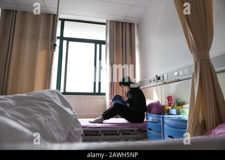 (200209) -- HEFEI, 9 février 2020 (Xinhua) -- Fang Ji lit un livre après un changement de nuit à l'hôpital du second Peuple de Hefei à Hefei, capitale de la province d'Anhui en Chine orientale, 3 février 2020. Fang Ji, 34 ans, est une infirmière qui travaille en unité de soins intensifs de l'hôpital des deuxième Personnes de Hefei. Après l'éclosion du nouveau coronavirus (2019-nCov), Fang et ses collègues restent 24 heures sur 24 à l'hôpital pour prendre soin des patients en équipe. Le balcon de la maison de Fang se trouve en face de l'hôpital. Pour réconforter deux petits fils qui la ratent mal à la maison, Fang leur a dit qu'ils c Banque D'Images