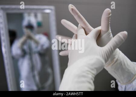 (200209) -- HEFEI, 9 février 2020 (Xinhua) -- Fang Ji met des gants médicaux de protection avant d'entrer dans le service d'isolement de l'hôpital du second Peuple de Hefei à Hefei, capitale de la province d'Anhui en Chine orientale, 6 février 2020. Fang Ji, 34 ans, est une infirmière qui travaille en unité de soins intensifs de l'hôpital des deuxième Personnes de Hefei. Après l'éclosion du nouveau coronavirus (2019-nCov), Fang et ses collègues restent 24 heures sur 24 à l'hôpital pour prendre soin des patients en équipe. Le balcon de la maison de Fang se trouve en face de l'hôpital. Pour réconforter deux petits fils qui la ratent mal Banque D'Images