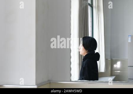 (200209) -- HEFEI, 9 février 2020 (Xinhua) -- Fang Ji stares à la direction de sa maison après un changement de nuit à l'hôpital du second Peuple d'Hefei à Hefei, capitale de la province d'Anhui en Chine orientale, 3 février 2020. Fang Ji, 34 ans, est une infirmière qui travaille en unité de soins intensifs de l'hôpital des deuxième Personnes de Hefei. Après l'éclosion du nouveau coronavirus (2019-nCov), Fang et ses collègues restent 24 heures sur 24 à l'hôpital pour prendre soin des patients en équipe. Le balcon de la maison de Fang se trouve en face de l'hôpital. Pour réconforter deux petits fils qui ratent mal sa maison, Fan Banque D'Images