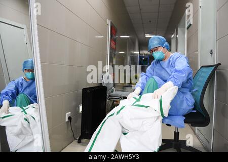 (200209) -- HEFEI, 9 février 2020 (Xinhua) -- Fang Ji met une combinaison protectrice avant d'entrer dans le service d'isolement de l'hôpital du second Peuple de Hefei à Hefei, capitale de la province d'Anhui en Chine orientale, 6 février 2020. Fang Ji, 34 ans, est une infirmière qui travaille en unité de soins intensifs de l'hôpital des deuxième Personnes de Hefei. Après l'éclosion du nouveau coronavirus (2019-nCov), Fang et ses collègues restent 24 heures sur 24 à l'hôpital pour prendre soin des patients en équipe. Le balcon de la maison de Fang se trouve en face de l'hôpital. Pour réconforter deux petits fils qui ratent mal à la maison Banque D'Images