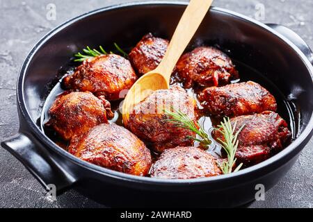 Gros plan des cuisses de poulet tendre et juteuse de moutarde brune de sucre dans un plat de cuisson sur une table en béton, vue horizontale d'en haut Banque D'Images