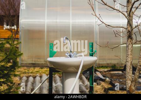 Évier et robinet dans le jardin. Robinet d'eau à l'extérieur de la maison. Arrière-cour de la maison d'été. Plus proche du concept de la nature Banque D'Images