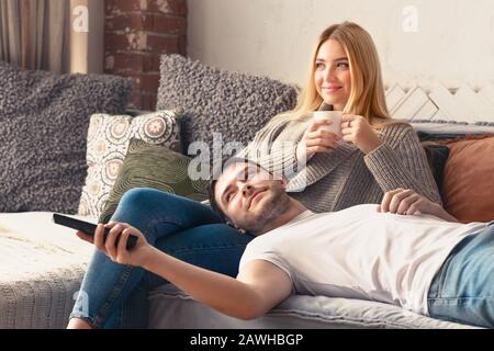 Jeune couple heureux se détendre à la maison et regarder la télévision Banque D'Images