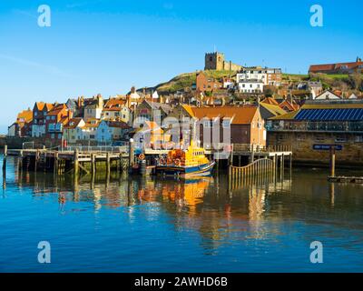 Port de Whitby avec la station de sauvetage RNLI et l'église St Mary's en hiver après-midi lumière du soleil Banque D'Images