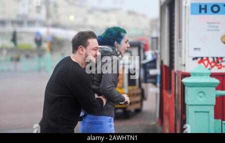 Brighton Royaume-Uni 9 février 2020 - un couple s'accroche sur le front de mer de Brighton dans des vents forts tandis que la tempête Ciara frappe la Grande-Bretagne avec des avertissements d'ambré étant donné dans tout le pays, les vents forts sont censés causer des dommages et un danger potentiel pour la vie: Crédit Simon Dack / Alay Live News Banque D'Images