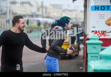 Brighton Royaume-Uni 9 février 2020 - un couple s'accroche sur le front de mer de Brighton dans des vents forts tandis que la tempête Ciara frappe la Grande-Bretagne avec des avertissements d'ambré étant donné dans tout le pays, les vents forts sont censés causer des dommages et un danger potentiel pour la vie: Crédit Simon Dack / Alay Live News Banque D'Images