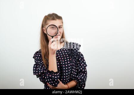 fille dans une robe noire heureuse femme regarde par loupe Banque D'Images