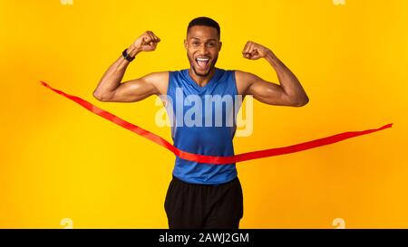 Heureux homme noir célébrant le succès briser la corde de finition Banque D'Images