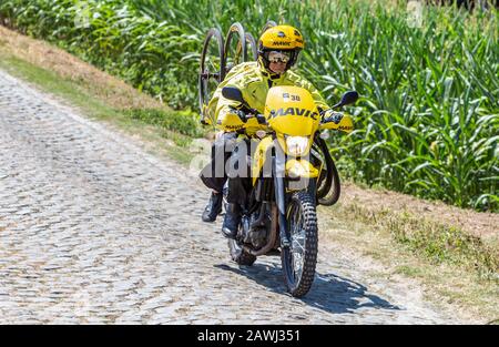 Paver Escaudoeuvres A Thun, France - 15 juillet 2018: La moto jaune de service de Mavic conduisant sur une route pavée, pendant la phase 9 du Tour de F Banque D'Images