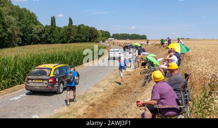 Paver Escaudoeuvres a Thun, France - 15 juillet 2018: Spectateurs attendant les cyclistes tandis que les véhicules techniques passent sur la route pavée pendant t Banque D'Images