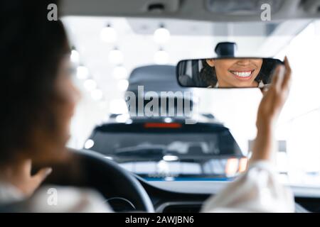 Femme Non Reconnaissable Dans Les Rétroviseurs De Contrôle De Siège Conducteur Dans Le Hall D'Exposition De La Concession Banque D'Images