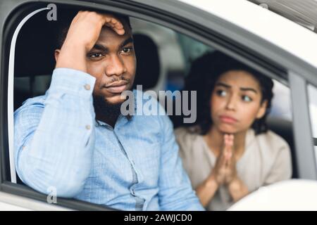 Femme Demandant Au Mari D'Acheter Une Voiture Chère Assis En Auto Banque D'Images