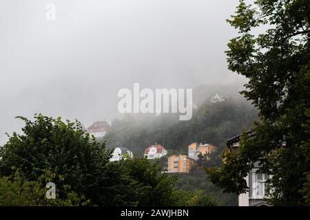 Maisons à flanc de coteau à Floyfjellet lors d'une journée d'automne pluvieux et en partie brumeuse à Bergen, Norvège Banque D'Images