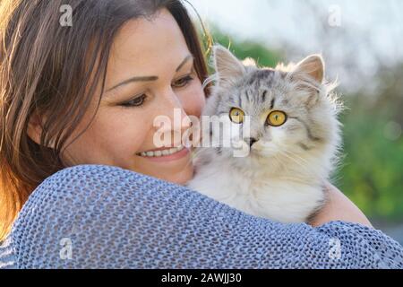 Portrait d'une femme mûre avec chat gris moelleux. Femme tenant l'animal dans ses bras Banque D'Images