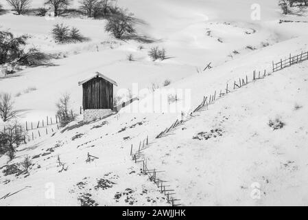 Ancienne grange en bois dans le champ, paysage de neige de montagne d'hiver Banque D'Images