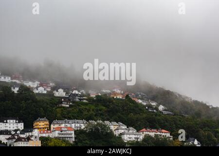 Maisons à flanc de coteau à Floyfjellet sur une pluie et en partie brumeuse de sorte que le sommet n'est pas visible un jour d'automne à Bergen Norvège Banque D'Images