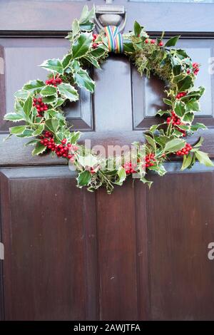 Couronne de Noël maison accrochée à la porte d'entrée, Royaume-Uni. Banque D'Images