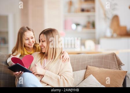 Portrait chaud et tonicité de la petite fille mignonne donnant une carte en forme de coeur à la mère heureuse le jour De La Mère ou la Saint Valentin, espace de copie Banque D'Images