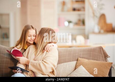 Portrait chaud et tonicité de la petite fille mignonne donnant une carte de vacances à la mère heureuse le jour De La Mère ou de la Saint Valentin, espace de copie Banque D'Images