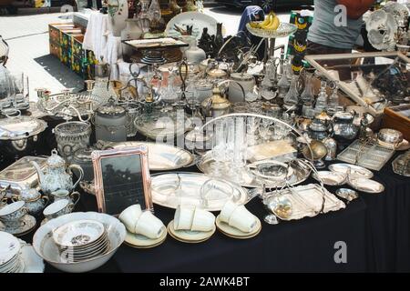 Assortiment de couverts, de verrerie et de vaisselle sur une table au marché aux puces Banque D'Images