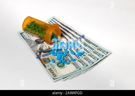 Flacon de comprimé de médicament de prescription avec facture de 100 dollars isolée sur fond blanc. Concept de hausse des coûts des médicaments, des soins médicaux, des assurances et des soins de santé Banque D'Images