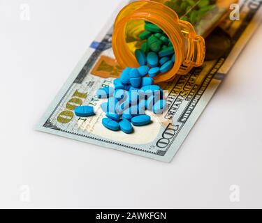 Flacon de comprimé de médicament de prescription avec facture de 100 dollars isolée sur fond blanc. Concept de hausse des coûts des médicaments, des soins médicaux, des assurances et des soins de santé Banque D'Images