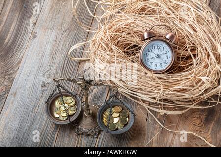 Le temps d'équilibrage et le Temps d'argent est le concept d'argent avec pile de pièces avec sablier sur table en bois. Banque D'Images